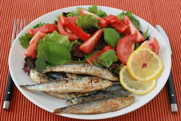Fried sardines with lemon and salad — Stock Photo, Image