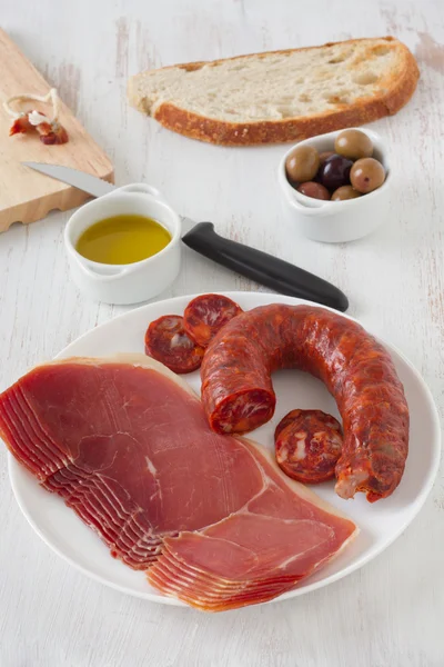 Salsichas e prosciutto no prato — Fotografia de Stock