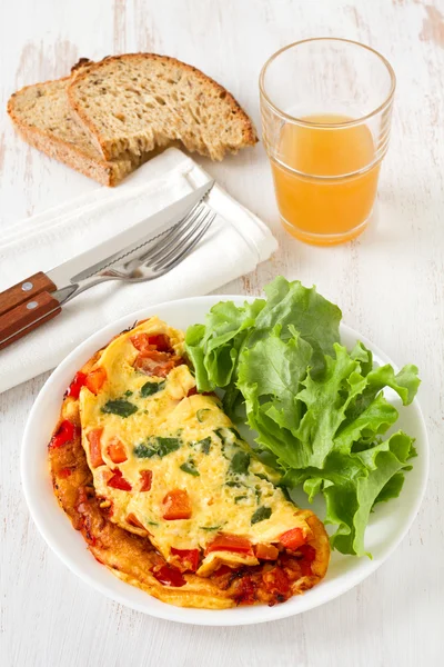 Omelet with lettuce and glass of juice — Stockfoto