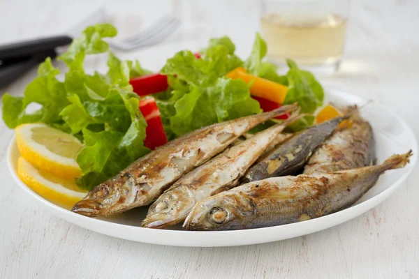 Fried fish with lemon and salad — Stock Photo, Image