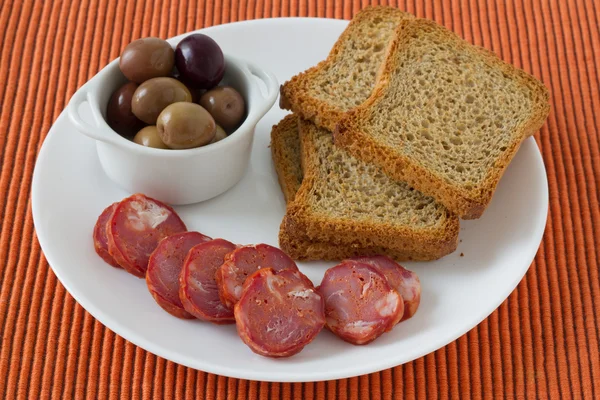Sausages with toasts and olives — Stock Photo, Image