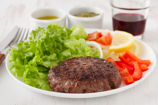Гамбургер на гриле с салатом — стоковое фото