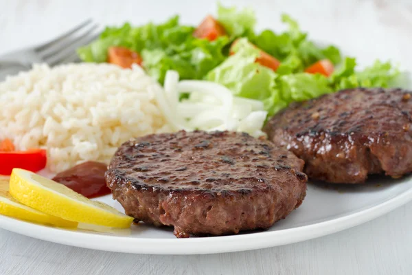 Hambúrguer grelhado com arroz e salada — Fotografia de Stock
