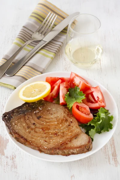 Gebratener Thunfisch mit Salat und Zitrone auf dem Teller — Stockfoto