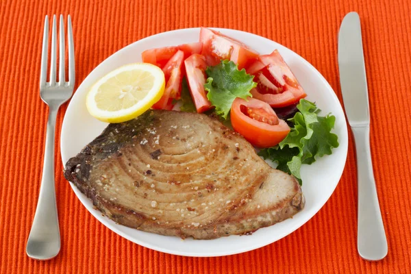 Smażone tuńczyka z sałatką i cytryna na talerzu — Zdjęcie stockowe