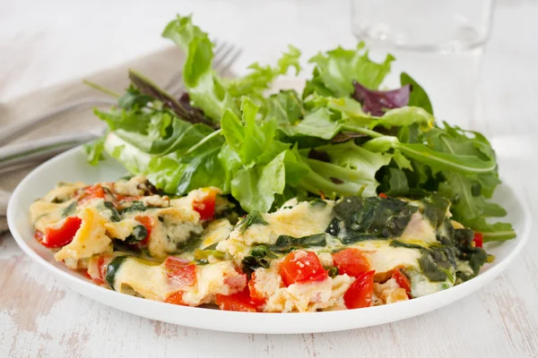 Омлет с овощами и салатом на тарелке — стоковое фото