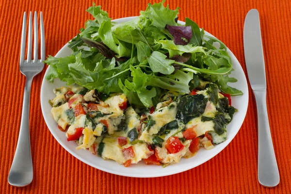 Омлет с овощами и салатом на тарелке — стоковое фото