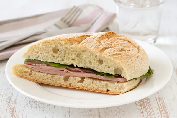 Бутерброд с ветчиной и салатом на тарелке — стоковое фото