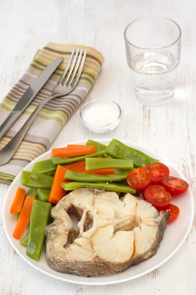 Peixe cozido com legumes no prato — Fotografia de Stock