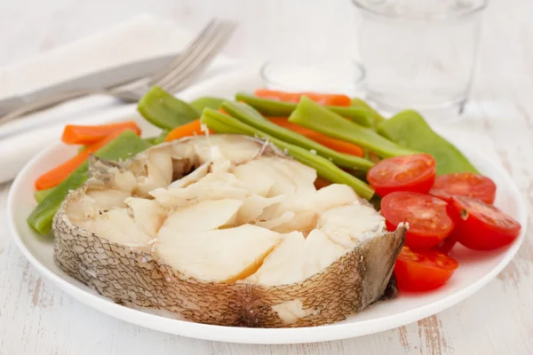 Вареная рыба с овощами на тарелке — стоковое фото