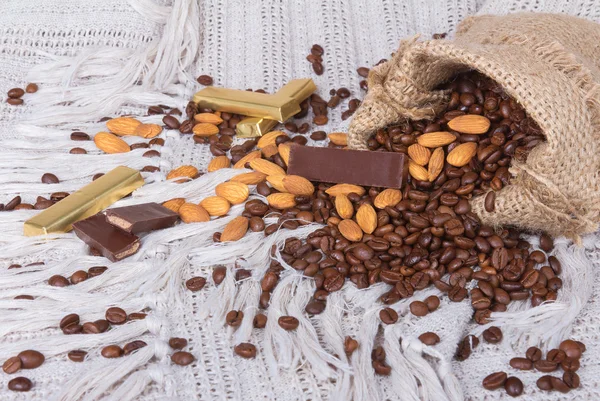 Chocolates, granos de café y almendras en saco de lona —  Fotos de Stock