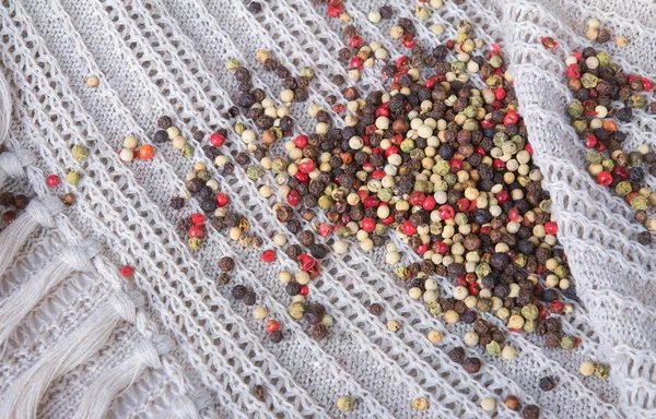 Grãos de pimenta coloridos em um fundo de lona — Fotografia de Stock