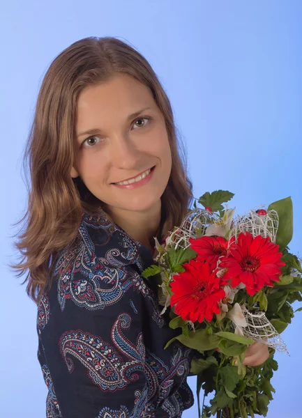 Cute young women with flowers over blue backgroung — Stockfoto