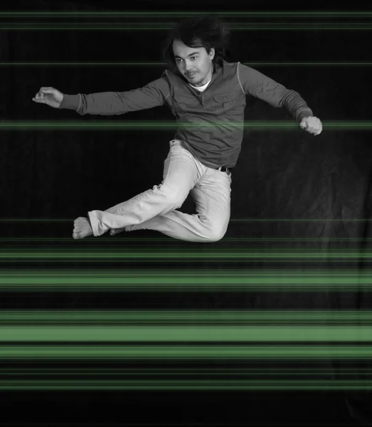 Homme sautant avec des rayons laser, sur noir — Photo