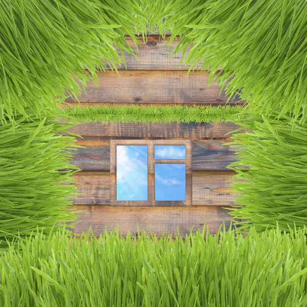 Casa de grama verde conceitual no fundo de madeira — Fotografia de Stock