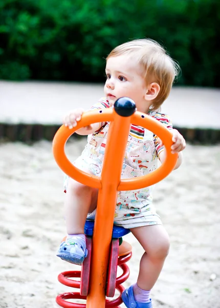 Little blonde boy playing on the swing. Summer — Stock Photo, Image