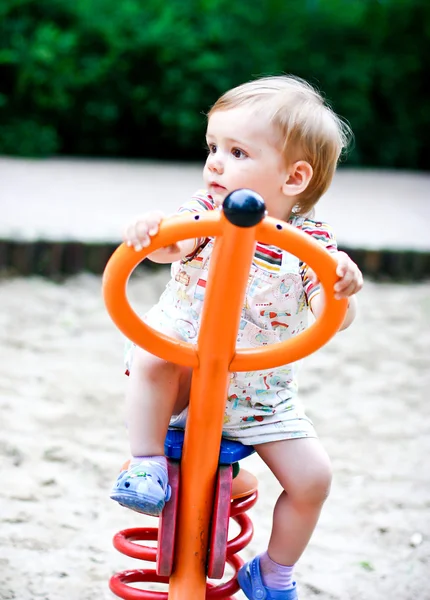 Niño rubio jugando en el columpio. Verano — Foto de Stock