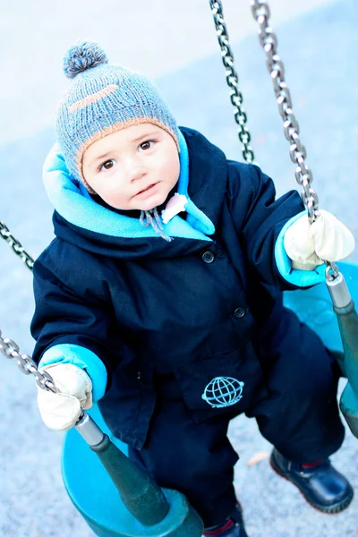 Portrait d'enfant sur aire de jeux balançoire à l'extérieur — Photo