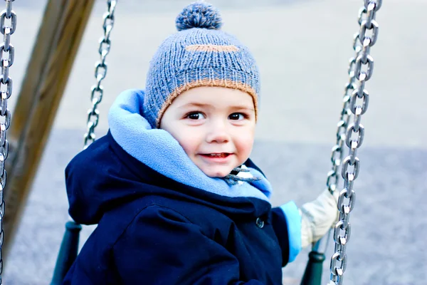 Um rapazinho a brincar num baloiço. Inverno — Fotografia de Stock
