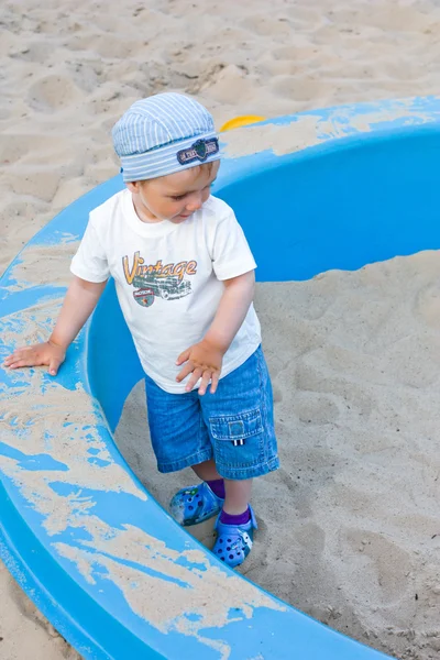 Pequeño niño jugar en la caja de arena —  Fotos de Stock