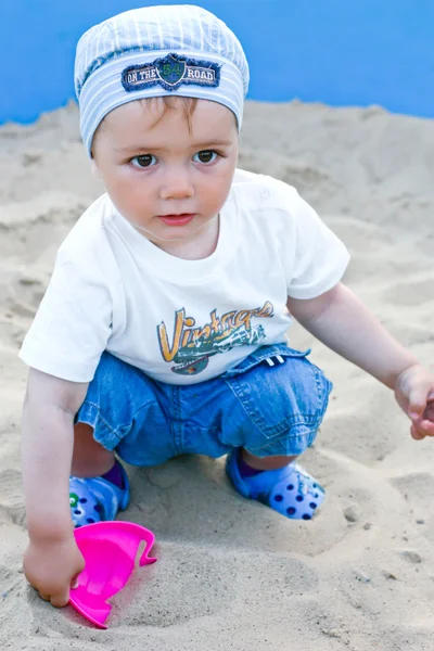 Очаровательный малыш играет в песочнице. Лето — стоковое фото