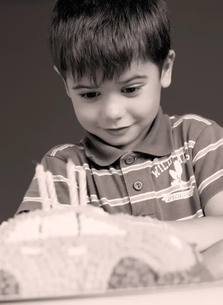 男孩吹蜡烛蛋糕，快乐的生日派上 — 图库照片