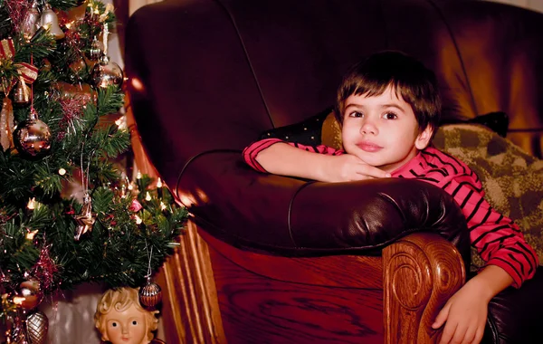 一个有吸引力的男孩附近一棵圣诞树，在晚上的肖像 — 图库照片