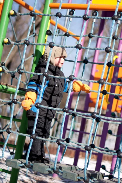 Boy is playing on winter playground — Stock Photo, Image