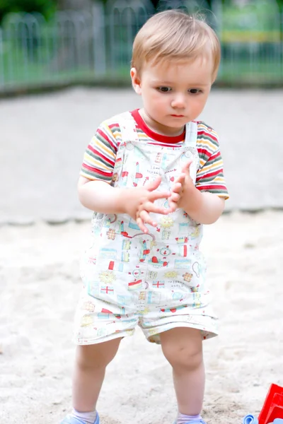 Малыш играет в песочнице на детской площадке — стоковое фото