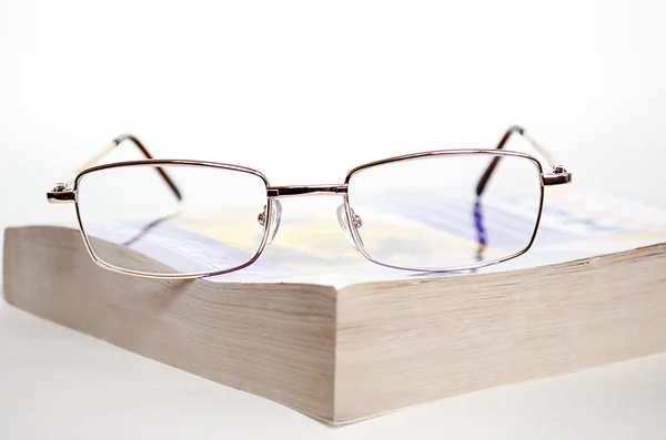 stock image Glasses on book.