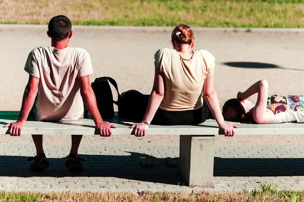 Jovens absorvendo o sol no banco — Fotografia de Stock