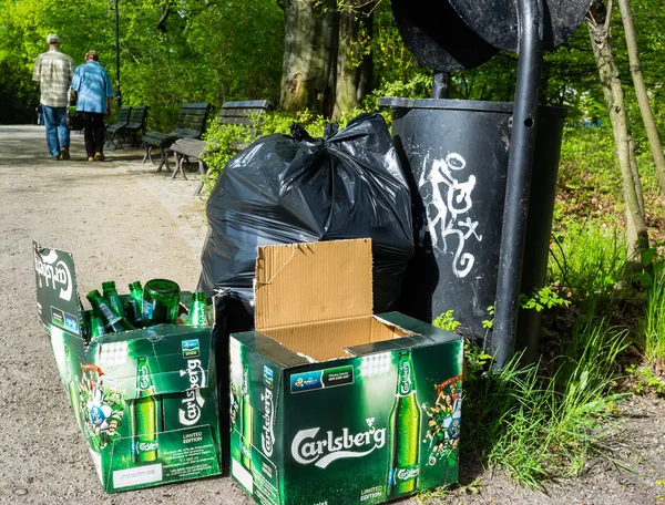 Carlsberg fles bier in de buurt van nest bin in Pools park — Stockfoto