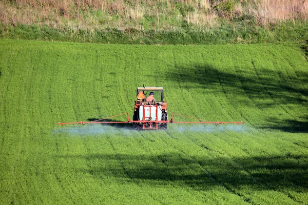 stock image Farm tractor spraying field before planting