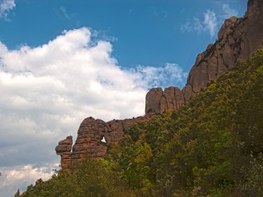 Bulutlu gökyüzünde Montserrat Dağı. Kayalık Dağ oluşumu