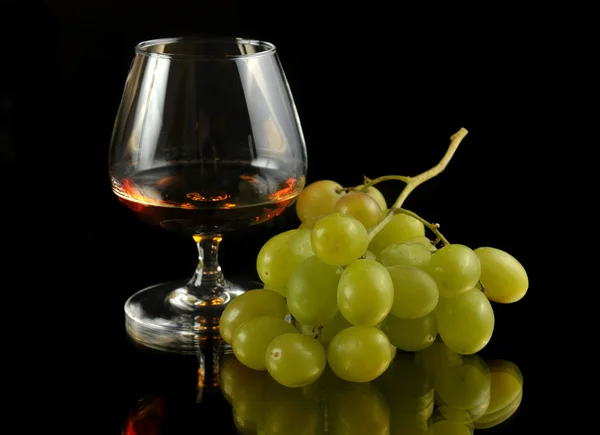 stock image Glass of brandy and grapes