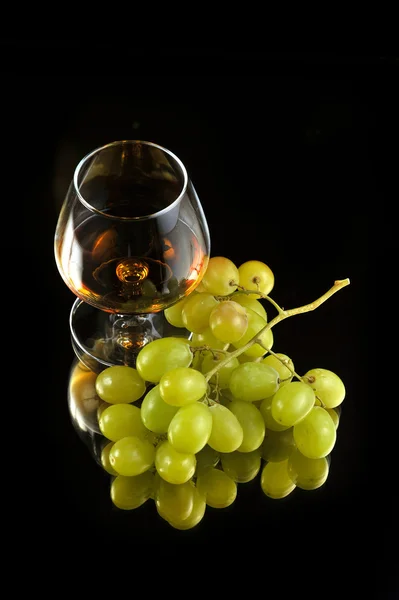 stock image Glass of brandy and grapes