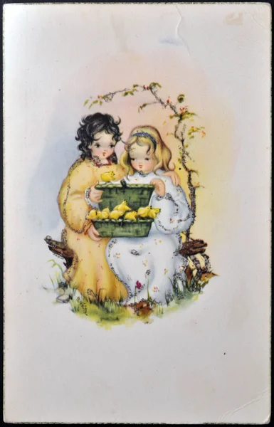ESPANHA - CIRCA 1959: Um cartão postal impresso na Espanha mostra duas meninas sentadas brincando com um pintinho amarelo, por volta de 1959 — Fotografia de Stock