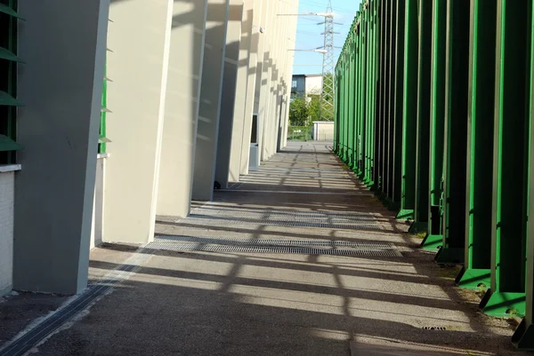 Skuggig stig med en vägg och grönt rör — Stockfoto