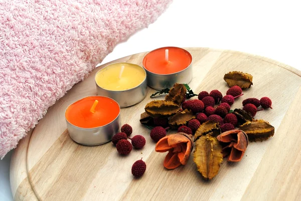 Three candles with dried flowers in wooden dish — Stock Photo, Image