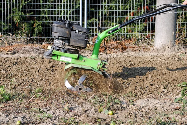 Bahçede çalışan yeşil rotary tiller — Stok fotoğraf