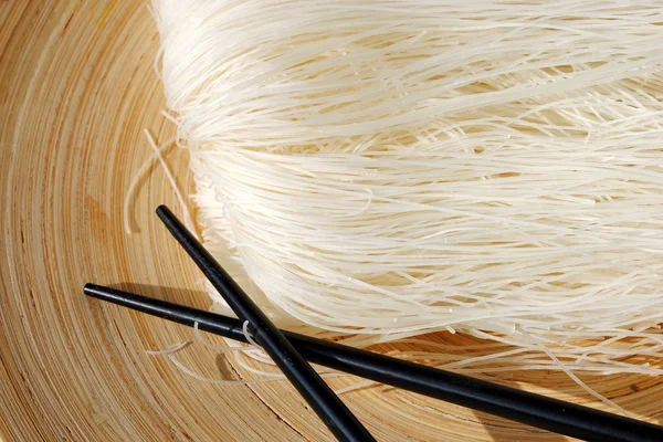 Ryż igły na drewniane naczynie okrągłe pałeczkami — Zdjęcie stockowe