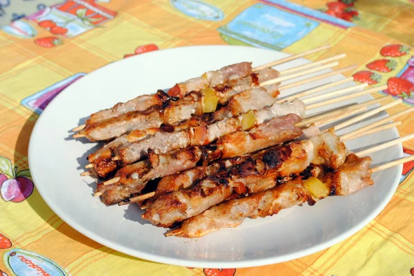 Cocked pork kabobs grilled on skewers in a plate — Stock Photo, Image