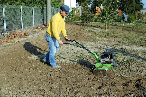 Middle age man with a rototiller in the garden — Stock Photo, Image