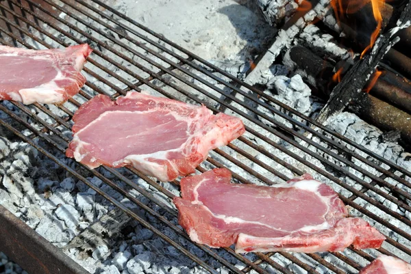 Raw pork chops grill on a barbecue — Stock Photo, Image