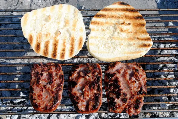 Salsiccia di maiale alla griglia e pane arrosto su un barbecue — Foto Stock