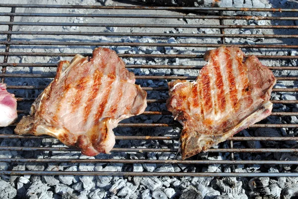 Costeletas de porco grelhadas em um churrasco — Fotografia de Stock
