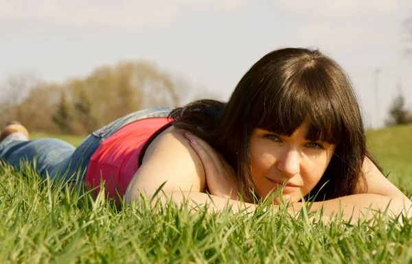 Mooi meisje in het groene gras — Stockfoto