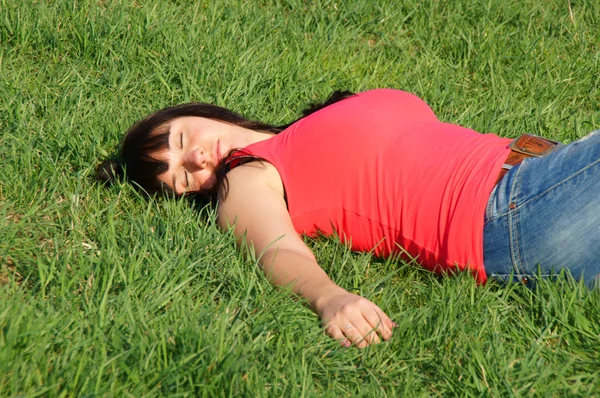 Soñando chica bonita en la hierba verde — Foto de Stock