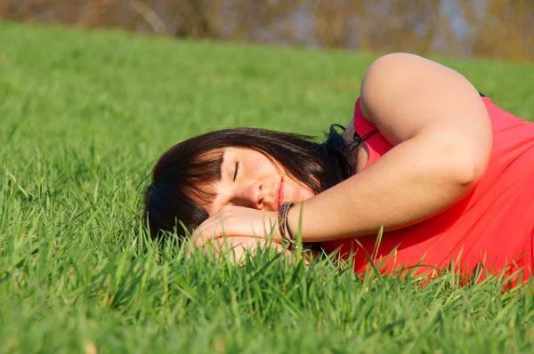 Mooi meisje in het groene gras dromen — Stockfoto
