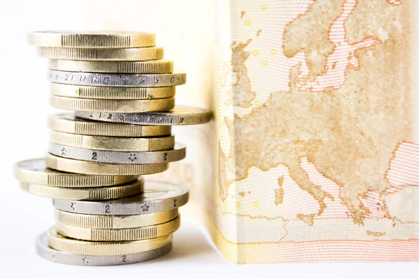 Pila de monedas en euros y banco — Foto de Stock